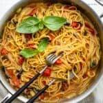 A pan of one pan pasta with serving utensils inside.