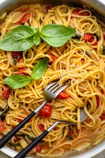 A pan of one pan pasta with serving utensils inside.
