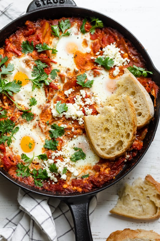 Close up shot of Shakshuka with feta cheese topped with bread slices