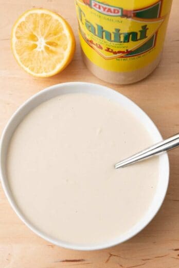 Tahini sauce in a large bowl with juiced lemons