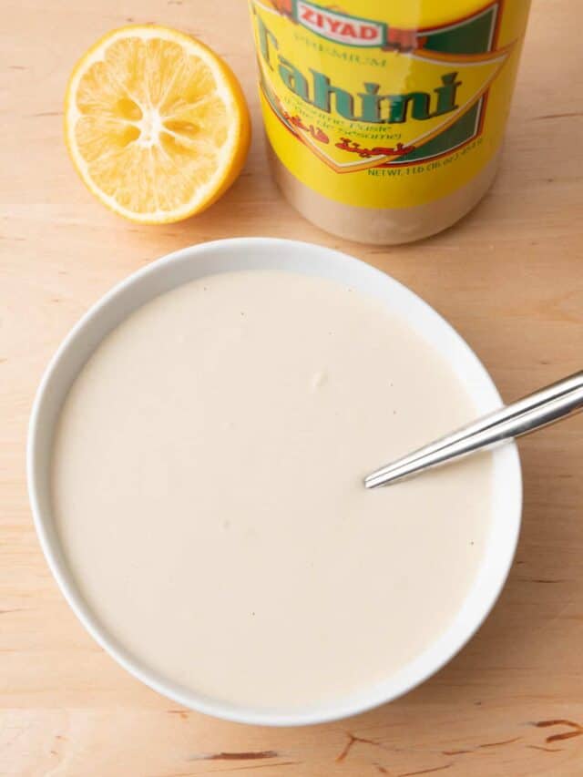 Tahini sauce in a large bowl with juiced lemons