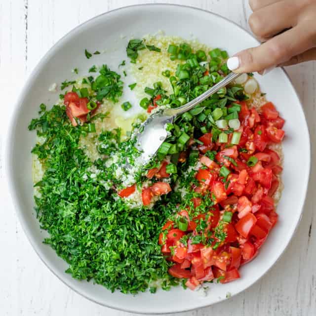 Mixing the tabbouleh.