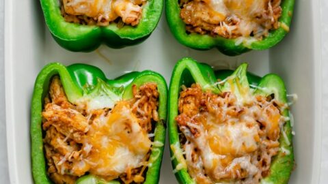 Chicken stuffed peppers in a white baking dish when they come out of oven