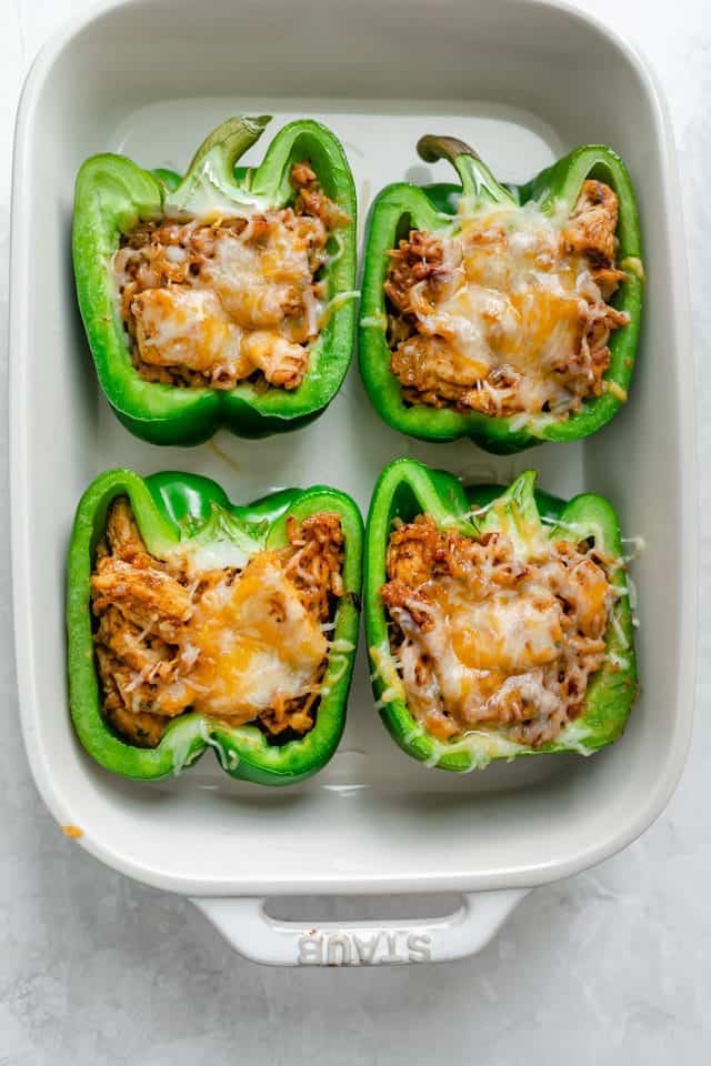 Chicken stuffed peppers in a white baking dish when they come out of oven