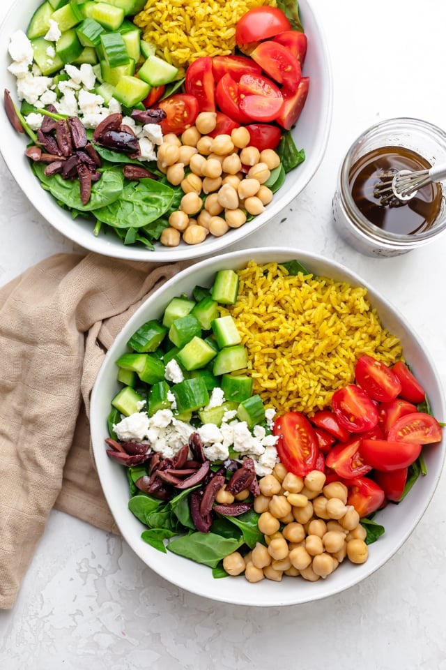 Two large bowls of the salad with dressing on the side