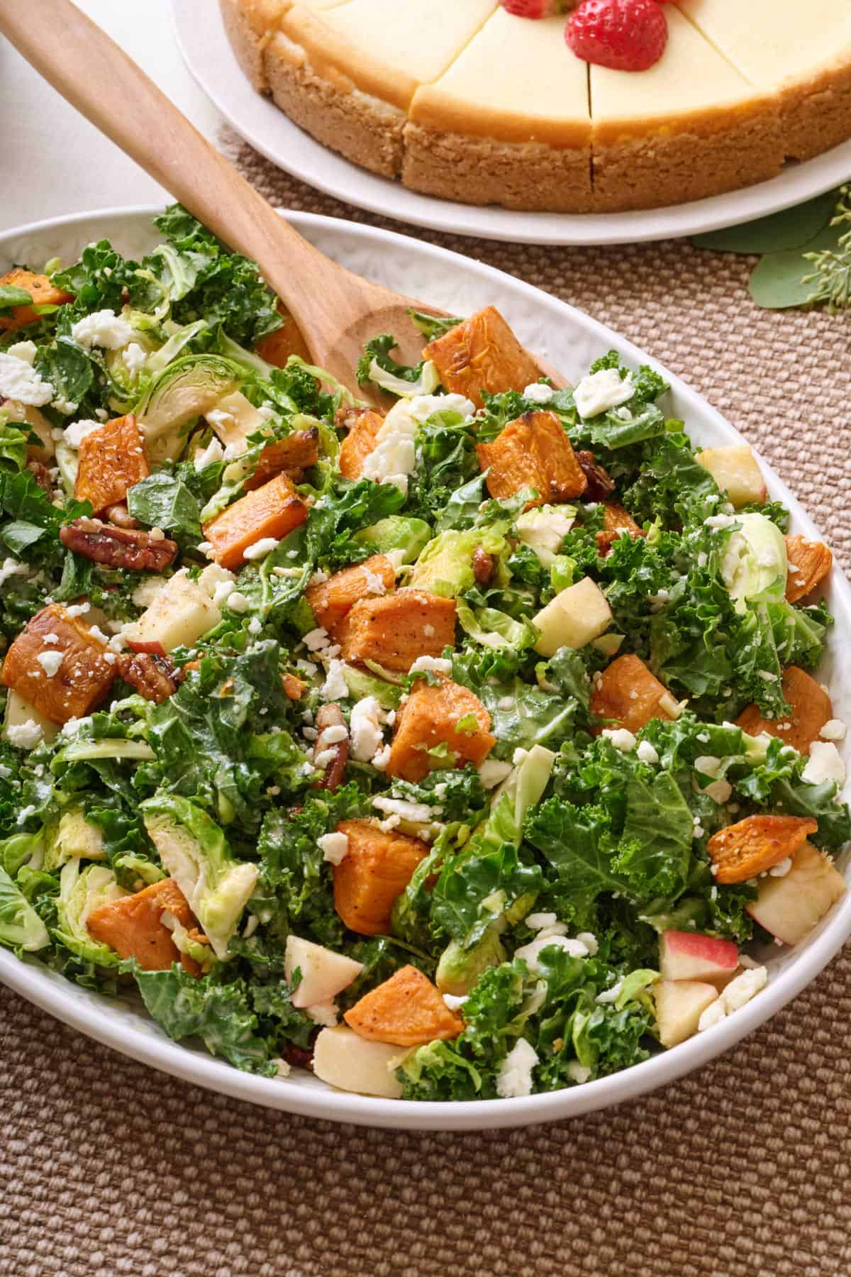 Fall harvest salad on a platter with a serving spoon dipped in.