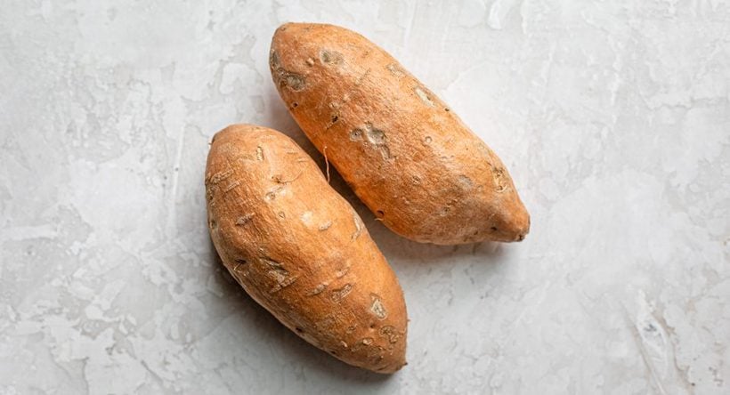 Two medium size sweet potatoes potatoes before peeling and cutting