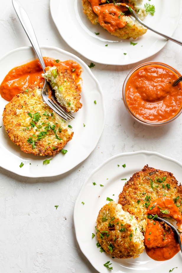 Cauliflower fritters on individual plates served with a marinara sauce
