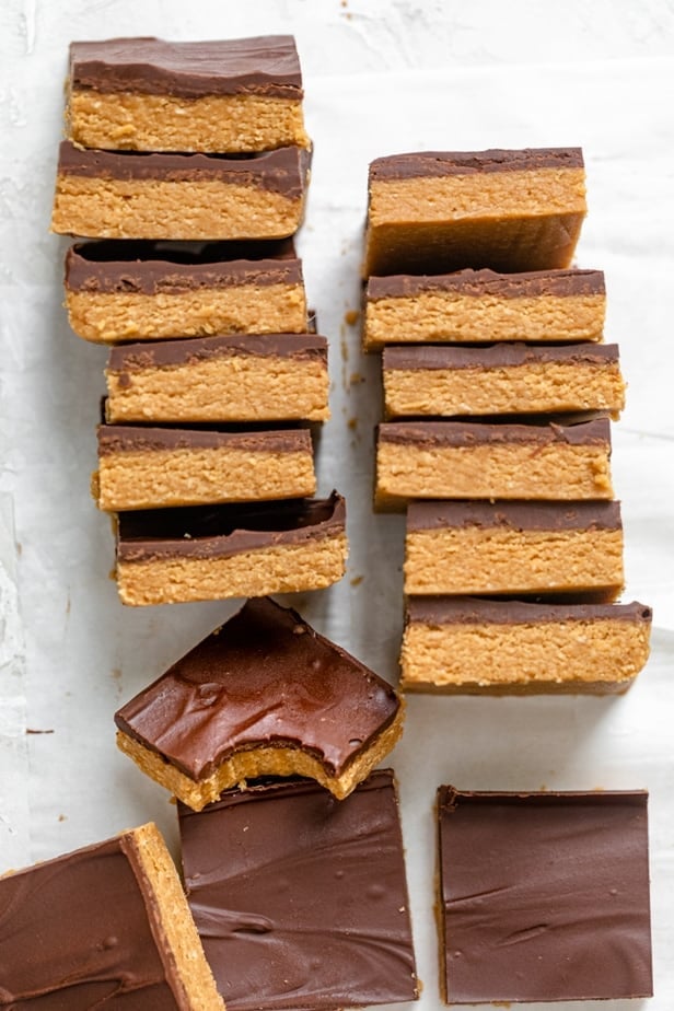 Stack of chocolate peanut butter bars with one bite taken out of one of them
