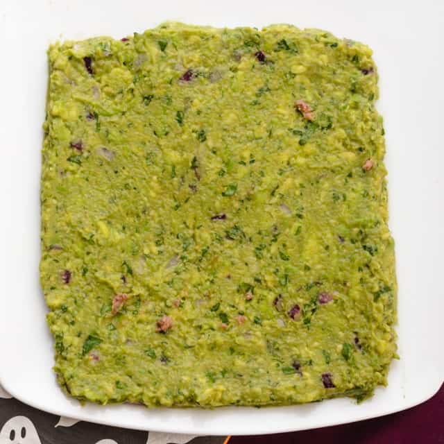 Guacamole laid out on a plate in a square shape.