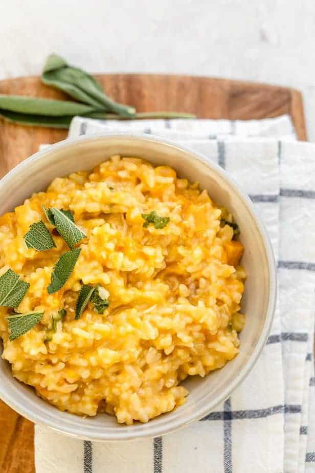Final cooked butternut squash risotto serve in a small bowl garnished with sage