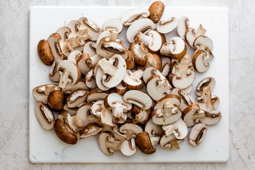 Sliced mushrooms on cutting board before cooking
