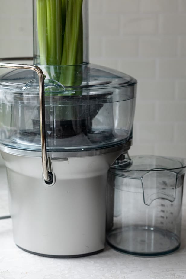 Celery sticks inside a juicer before juicing