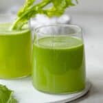Two glass cups of fresh celery juice made in a juicer
