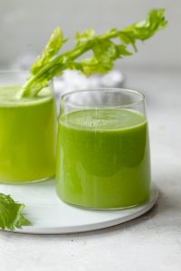 Two glass cups of fresh celery juice made in a juicer