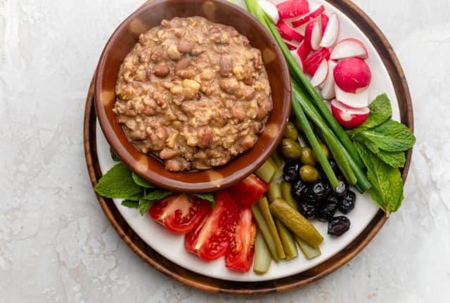 Completed recipe served in a small bowl and sitting on a large platter full of vegetables