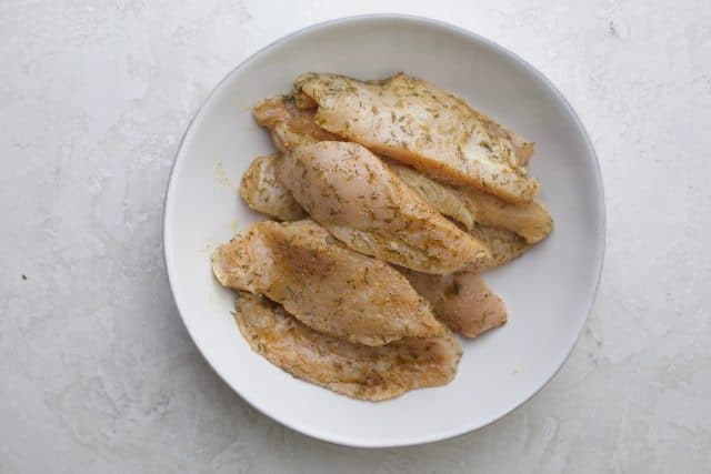 Chicken tenderloins marinating in the lemon, olive oil and herbs