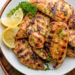 Final grilled chicken tenders served with lemon slices and garnished with parsley