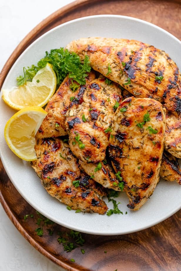 Final grilled chicken tenders served with lemon slices and garnished with parsley