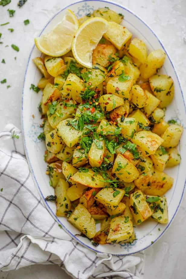 Lebanese Spicy Potatoes, also know as Batata Harra served with fresh cilantro and lemon wedges