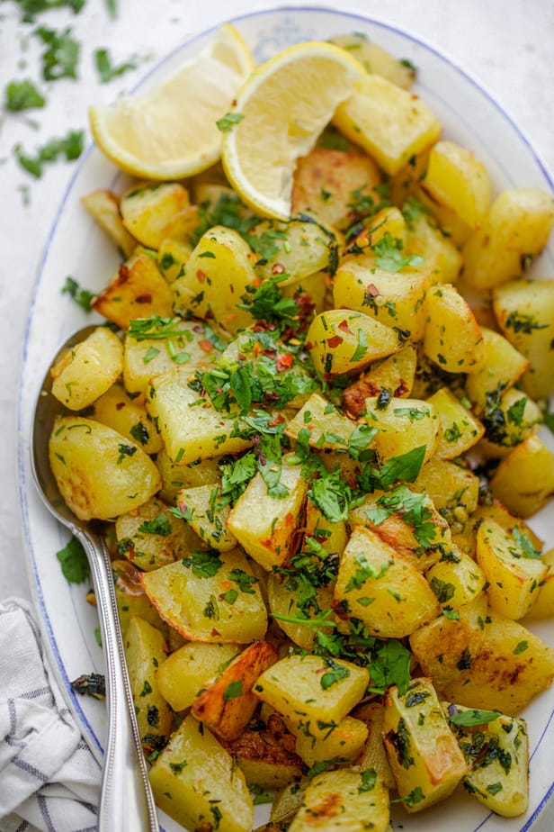 Close up shot of the Lebanese potatoes, batata harra with spoon for serving