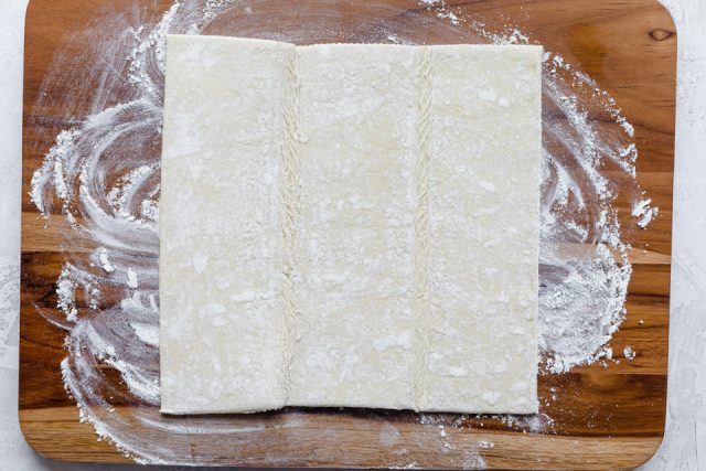 Puff pastry dough rolled out on cuttingboard