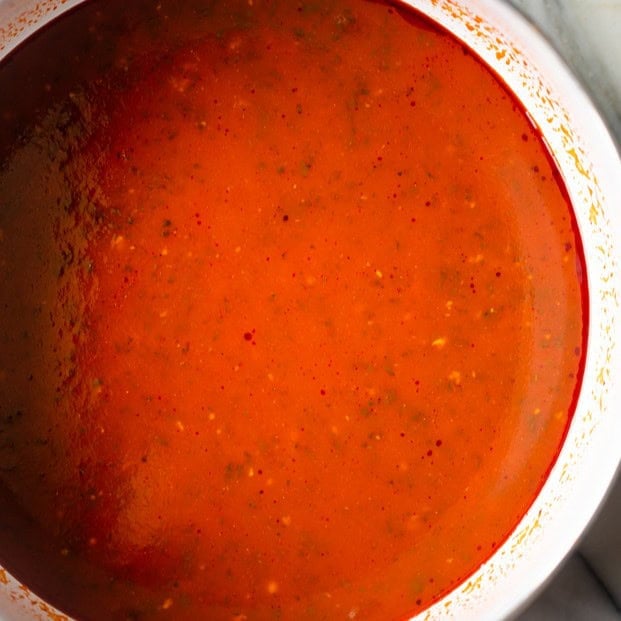 Tomato sauce and water added to a pot.