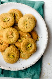 Plate of holiday pistachio cookies topped with pistachio pieces
