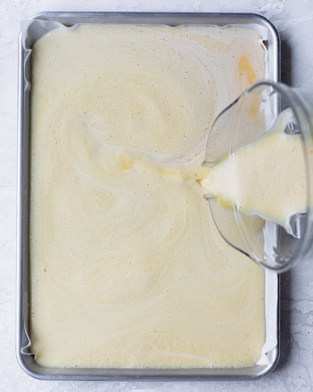 Pouring the egg mixture onto the sheet pan to make sheet pan eggs.