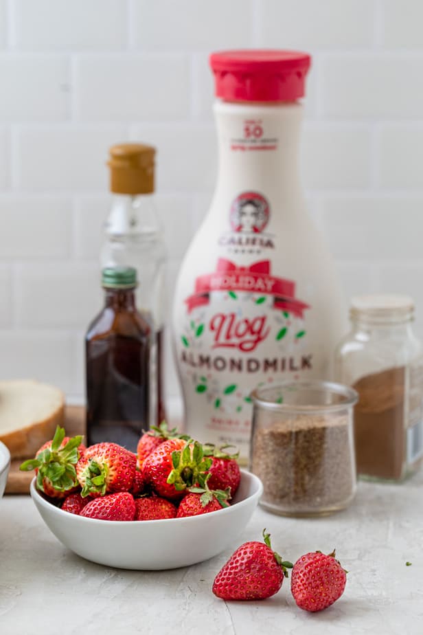 Ingredients to make the recipe along with bowl of strawberries for topping