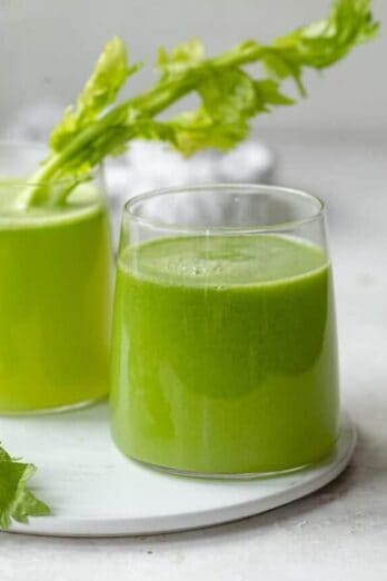 Two glass cups of fresh celery juice made in a juicer