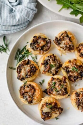 Plate of mushroom tartlets garnished with rosemary