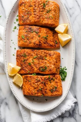 Air Fryer Salmon recipe garnished with lemon wedges and parsley
