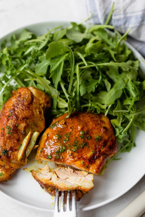 Pan seared chicken thighs served with arugula