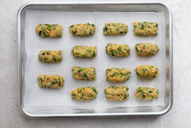 The zucchini mixture formed into the tater tot shapes and placed on baking sheet lined with parchment paper