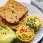 Breakfast egg cups served on a plate with toast and avocados