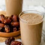 2 cups of date shakes with bowl of dates next to them