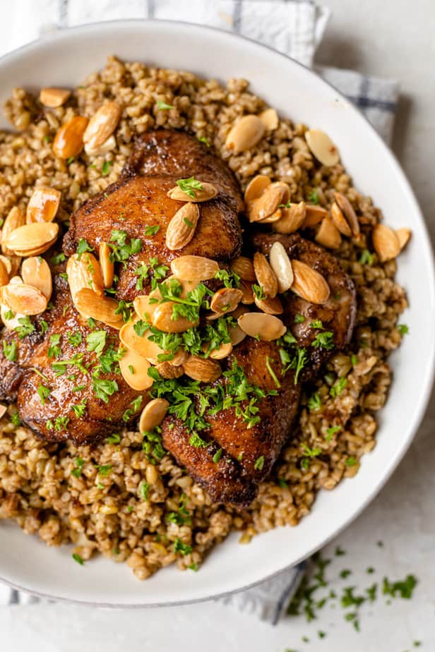 The meal served in a large white bowl and topped with toasted almonds