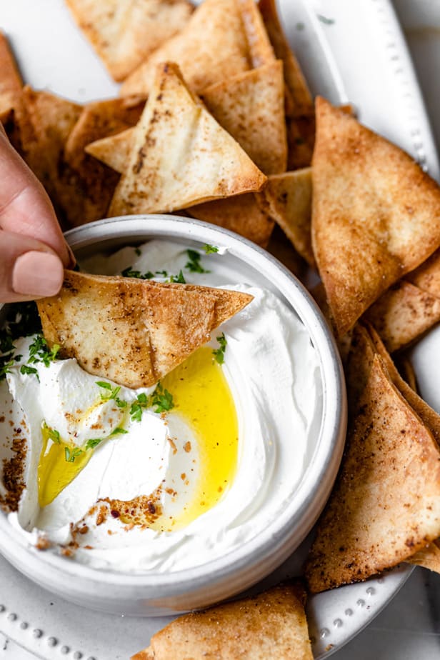 Dipping the pita chip into labneh