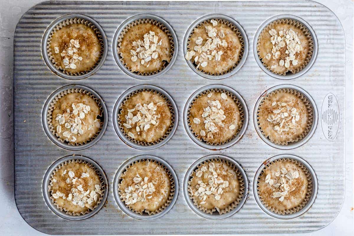 Muffin batter before baking in muffin tin lined with parchment paper