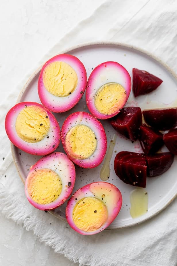 Beet pickled eggs on a plate with beets