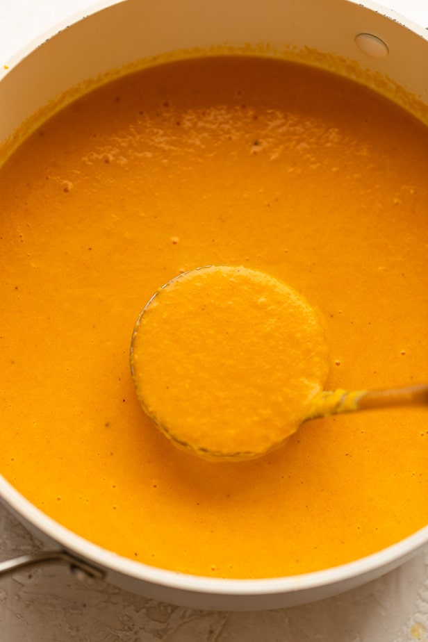 Carrot and ginger soup in a ladle