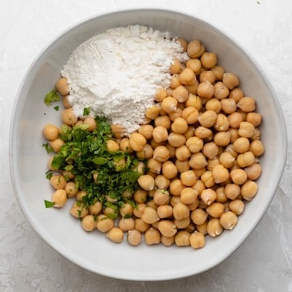 Ingredients for chickpea fritters in a bowl before combining.