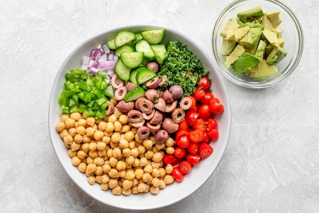 The salad ingredients in a white bowl before being mixed