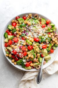 Large bowl of chickpea salad topped with feta cheese