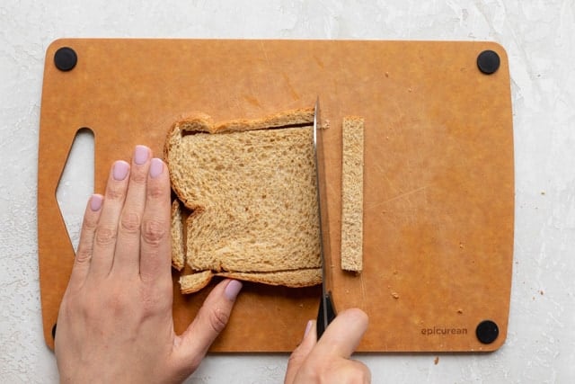 Cutting off the crusts from the bread