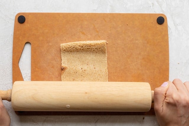 Rolling the bread to flatten it and make it easier for rolling