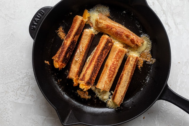 Cooking the grilled cheese dippers on a skillet