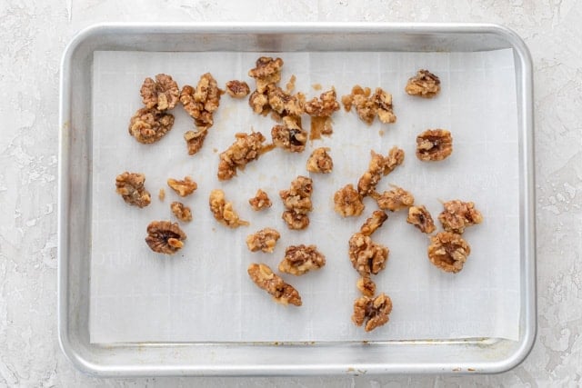 Candied walnuts on a parchment paper lined baking sheet
