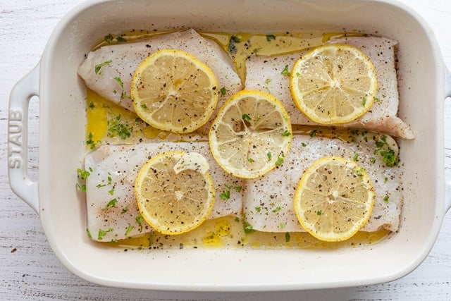 The fish topped with sliced lemon ready to cook